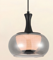 A modern pendant light with a large, rounded translucent smoky glass shade, a matte black neck, and a warm peach-colored textured inner shade, suspended against a solid light beige background.