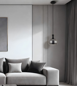 A modern living room scene featuring a light gray fabric sofa with dark gray and white throw pillows, a dark gray wall with vertical paneling, a black pendant light with a metallic silver globe shade, and a dark gray curtain.