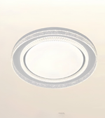 A modern circular flush-mount ceiling light fixture with concentric rings, featuring a frosted white center and textured clear outer rings, shown against a plain off-white background.