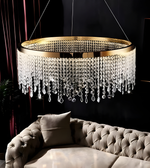 Luxury chandelier with crystal accents hanging above a sofa in a dimly lit room.