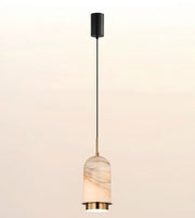A modern pendant light with a black cylindrical ceiling canopy, a slim black cord, and a warm white marble shade with gold-toned metal accents.