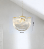 Modern pendant light with gold chain and ribbed glass shade on a white background