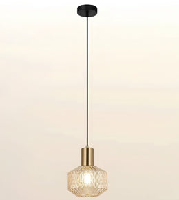 A modern pendant light with a black ceiling canopy and cord, a gold-finished neck, and a faceted clear glass shade that glows with a warm light, shown against a plain off-white background.