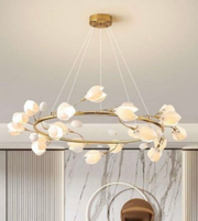 Modern chandelier with gold frame and white bulbs in a room with marble wall.