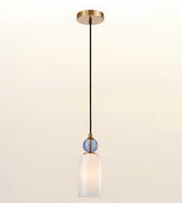 A modern pendant light fixture with a round gold ceiling canopy, a black cord, a small blue ribbed glass accent sphere, and a frosted white glass cylindrical shade, shown against a light beige gradient background.