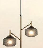 Modern two-light pendant lamp with a brushed brass/gold branch-like metal frame and textured gray glass shades, shown against a plain light beige background.