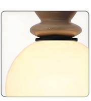 Close-up of a lamp with a glass shade and metallic base on a white background