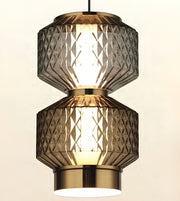 A modern two-tier pendant light fixture with textured, diamond-patterned smoked glass shades and polished brass-toned metal accents, shown illuminated against a plain light background.