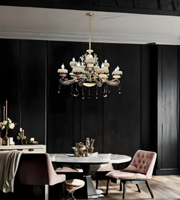 Dining room with a chandelier, table, and chairs against a dark wall.