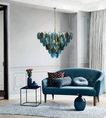 Modern living room with a blue sofa, decorative pillows, and a stylish chandelier.