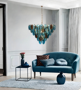 Modern living room with a blue sofa, decorative pillows, and a stylish chandelier.