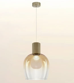 A modern pendant light with a clear ribbed glass shade and a brushed brass cylindrical neck, suspended by a thin cord from a matching ceiling canopy against a warm off-white background.