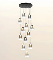 A modern multi-light chandelier with a circular black ceiling canopy and ten hanging bell-shaped frosted glass shades of varying sizes, shown against a plain light beige background.