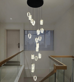 Modern chandelier hanging in a staircase area with a neutral color scheme.