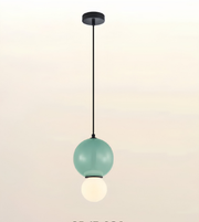 A modern pendant light fixture with a matte mint green upper globe, a black suspension rod and canopy, and a smaller glowing white lower globe, shown against a soft off-white gradient background.