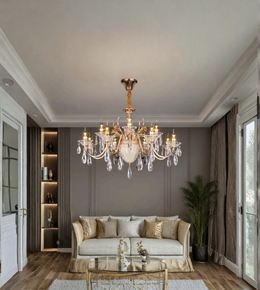 Luxury gold crystal chandelier suspended above a cream sofa in an elegant living room with neutral walls and warm interior lighting.