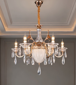 Detailed view of the chandelier's curved gold-tone arm and clear crystal-style hanging ornaments.