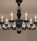  Black crystal chandelier featuring multiple candle-shaped lights, curved arms, and cascading transparent crystal-style ornaments.