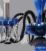 Detailed view of a blue and black multi-arm chandelier featuring curved arms, candle-shaped lights, and cascading clear decorative drops.