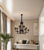Black modern multi-arm chandelier with warm candle-style lights suspended in an elegant neutral living space.
