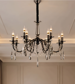 Black decorative chandelier featuring multiple candle-style lights, ornate curved arms, and hanging crystal-style accents.
