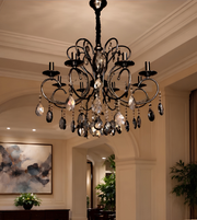 Detailed view of a luxury black chandelier featuring curved metal arms and cascading crystal accents.