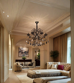 Black metal crystal chandelier suspended from the ceiling in an elegant living room with neutral furnishings.