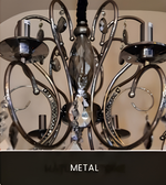 Close-up of an ornate black metal chandelier frame featuring curved arms and decorative detailing.