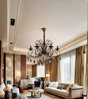 Luxury black metal crystal chandelier suspended from the ceiling of an elegant living room with neutral sofas, floor-to-ceiling curtains, and warm interior finishes.