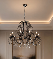 Ornate black crystal chandelier with sculptural curved arms, candle-style lights, and hanging crystal-style droplets in an elegant interior.
