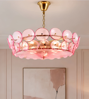 Pink circular disc chandelier with layered translucent discs, a golden suspension chain, and a sculptural contemporary design.