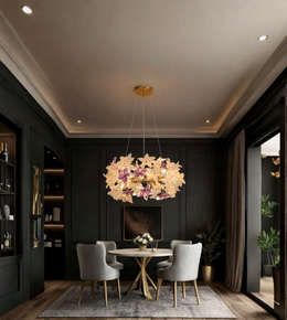A modern multi-light pendant chandelier with flower-shaped glass shades hangs over a dining table in a dark, elegant room with gray chairs and wood flooring.