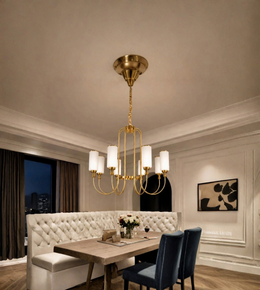 Gold EIGHT-light chandelier with white cylindrical shades suspended above a dining table in an elegant interior.