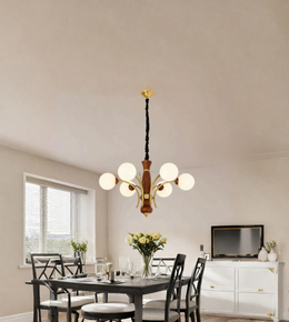 A modern multi-light chandelier with six white spherical glass globes and a warm wood-and-brass-toned central body, hanging in a dining room above a dark table.