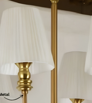 Close-up of the gold-tone metal chandelier frame and cream pleated lampshade, showcasing its decorative finish and detailing.