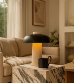 Modern stone table lamp with warm ambient glow on marble side table