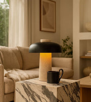 Modern stone table lamp with warm ambient glow on marble side table