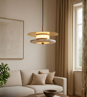 Contemporary disc pendant lamp with warm LED glow in a cozy neutral living room.