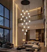 Modern glass drop cascade chandelier in a luxury double height living room with warm lighting