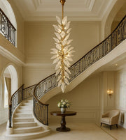 Elegant acrylic leaf cascade staircase chandelier with warm lighting in a luxury foyer
