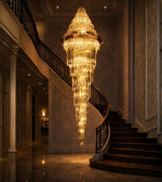 Royal glass spiral cascade staircase chandelier with warm lighting in a grand luxury interior