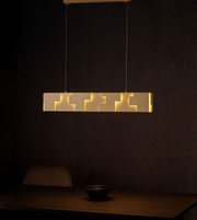 Geometric linear LED pendant light with warm illumination above a dining table in a modern interior