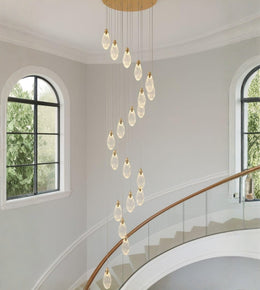 Crystal drop cascade staircase chandelier with modern teardrop pendants in a double height interior