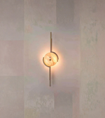 Modern wall sconce with a warm glow on a textured wall.

