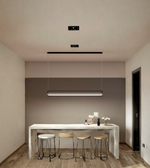 Modern kitchen with a dining table and stools, featuring pendant lights.