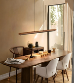 Dining area with a wooden table, chairs, and a lamp in a well-lit room.