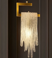 Decorative wall light fixture with gold fixture on a dark wall