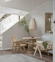 Modern dining area with a round table, chairs, and a hanging light fixture.