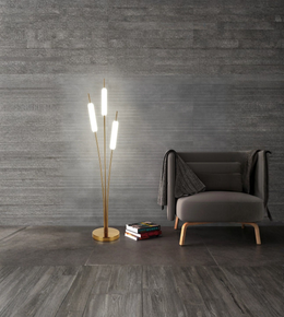 Modern brass floor lamp with frosted tube lights beside armchair