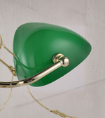 Close-up of green glass shade and brass arm of banker lamp